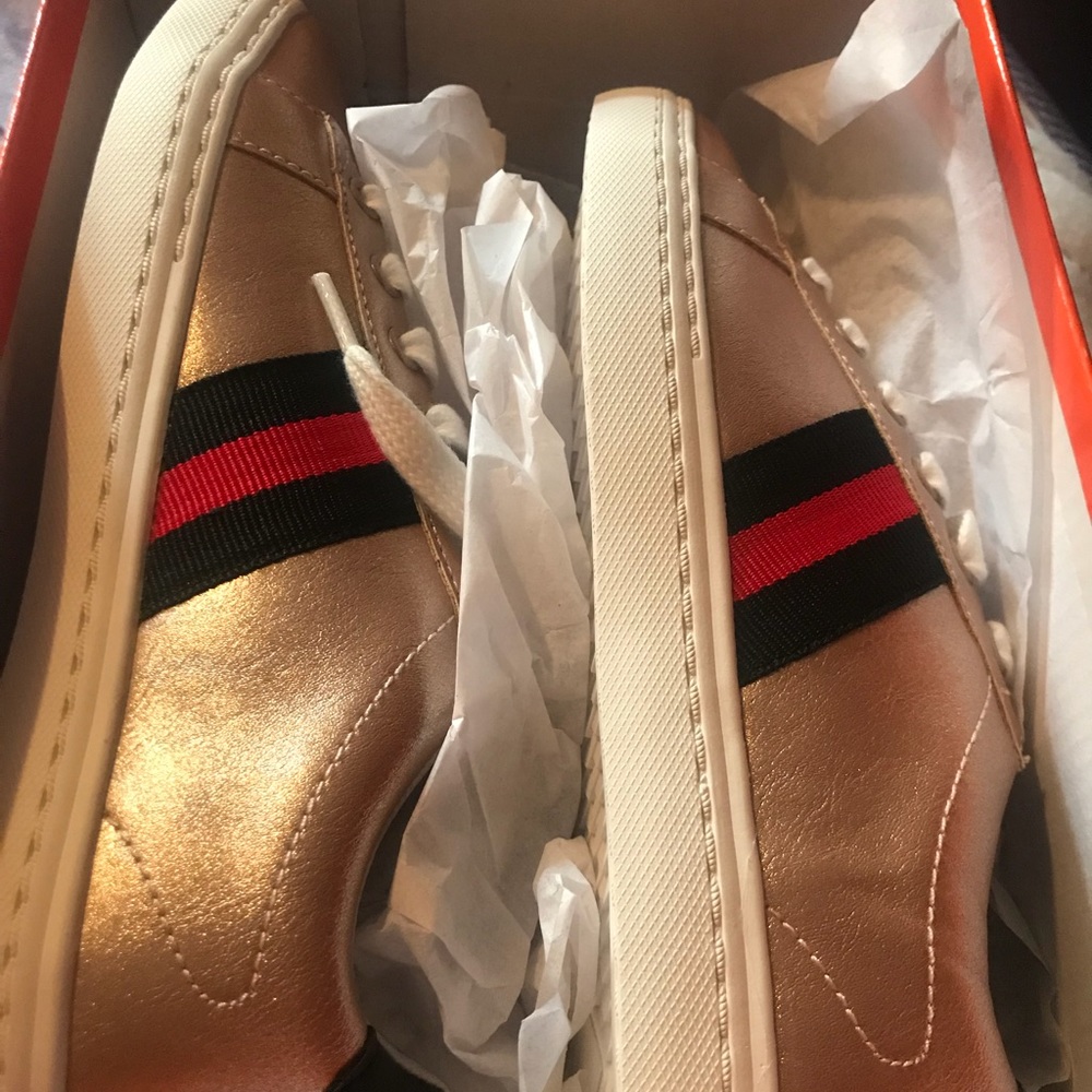 Gold sneakers with stripes on the side